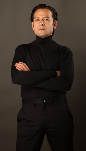 Tizoc Arroyo con cuello alto negro y brazos cruzados